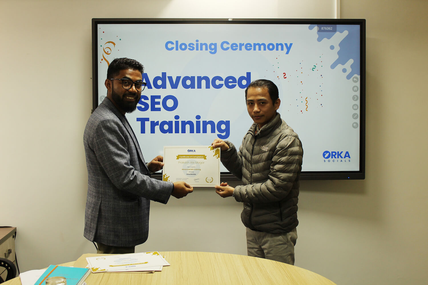 Rambabu Thapa handing SEO Mastery Course certificate to Prakash Ale Magar at the Orka Socials Lalitpur office during the graduation ceremony.
